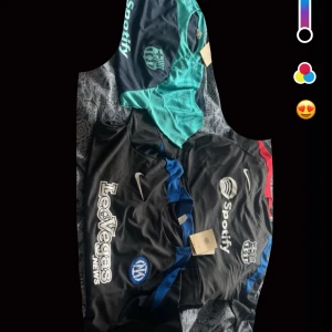 Svarta och turkosa fotbollströjor från Nike och Puma - Två svarta fotbollströjor från Nike med blå och röda detaljer, samt en turkos tröja från Puma. Alla har tryckta loggor och sponsortryck, bland annat Spotify och LeoVegas. Perfekt för dig som gillar snygga matchtröjor med klubbkänsla.