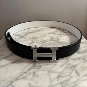 Reversible H-bälte - Säljer ett vändbart H-bälte i svart och vitt läder i mycket bra skick.