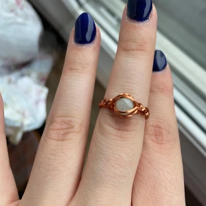 Handgjord ring med koppartråd och vit sten - Unik ring i koppartråd med en rund vit sten i mitten. Ringen har en bohemisk och stilren design som passar perfekt för dig som vill sticka ut. Perfekt accessoar för att lyfta din outfit.