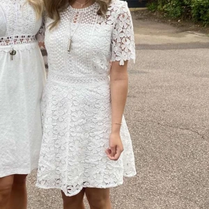 Studentklänning - Superfin vit klänning från Bubbleroom med blommig spets, kort ärm och markerad midja. Klänningen har dragkedja i ryggen och är helfodrad. Perfekt för student eller sommarens alla tillfällen! Endast använd en gång! Nypris:999❤️❤️