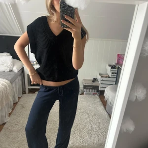 Svart stickad väst - Säljer en svart stickad väst med v-ringning och breda axlar. Nästan aldrig använd och säljs inte längre💕