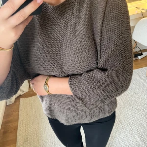 Stickad grå tröja med trekvartsärm - Säljer en stickad grå tröja med trekvartsärmar och rund halsringning. Tröjan har en avslappnad passform och är perfekt för lager-på-lager. Passar till både jeans och kjol.