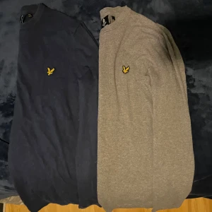 2 stickade tröjor från Lyle & Scott - Två klassiska tröjor från Lyle & Scott i färgerna mörkblå och grå. Båda har rund halsringning och den ikoniska gula loggan broderad på bröstet. Perfekta för lager-på-lager och stilrena outfits. Storlek (M) men är liten i storleken.