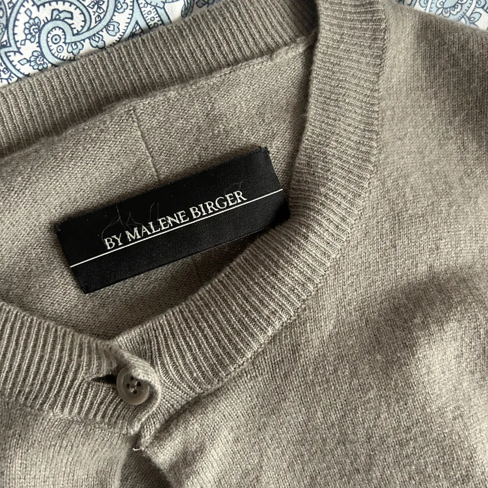 Säljer en klassisk beige kofta från By Malene Birger. Koftan har rund halsringning, knappar framtill och ribbade muddar vid ärmslut och nederkant. Perfekt att slänga över en topp eller t-shirt och passar till det mesta! . Neuletakit & Villapaidat.
