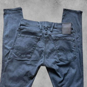 Svarta jeansbyxor från Replay - Snygga svarta jeansbyxor från Replay i modellen Anbass. De har en klassisk femficksdesign och en knappgylf.  L34 Hyperflex. Perfekta för en stilren look. Pris kan diskuteras