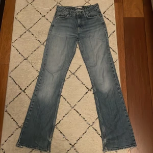 Blå jeans från gina tricot perfect jeans - Säljer ett par blå jeans från g perfect jeans i storlek 34. Byxorna är flared, klassisk femficksdesign och slitna detaljer vid benslut och bakficka. Perfekta för en avslappnad och trendig look. Köpte dom ett långt tag sedan men har växt ut dom. Hoppas att nästa ägare blir glad me dom jeansen. 