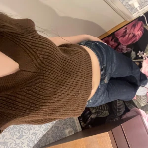 Brun ribbad stickad linnetopp från H&M Divided - Säljer en brun ribbad stickad linnetopp från H&M Divided. Toppen är ärmlös med djup v-ringning och har en croppad passform. Perfekt att styla med jeans eller kjol för en trendig look.