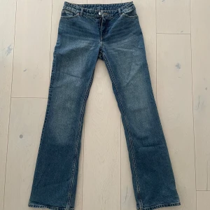 Blå bootcut jeans - Säljer ett par klassiska blå bootcut jeans med normal passform. Jeansen har fem fickor, knapp- och dragkedjegylf med utsvängda ben. Låg/medelhög midja.