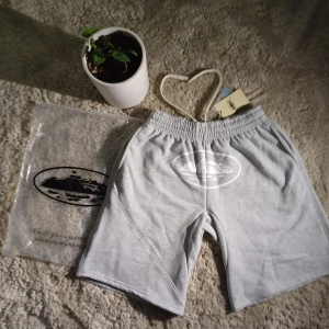 Gråa Corteiz shorts  - 📊Färg: Shortsen är hel svarta, med vitt insida och ett vitt Corteiz märke. Sedan är snörena även hel vitt.  📏Storlek(M): Jag är inte helt säker eftersom alla shorts kan variera beroende på märket och Materialet, fast dessa shorts är i storlek M. (Kolla måttet för bättre överblick!!)  📐Mått: Längden~20cm              Höjden~50cm  ♻️Kvaliteten: Shortsen är riktigt bra kvalitet. Endast testad en gång. Det finns inga märken och inga fläckar.  🧾Priset: Priset kan diskuteras!!