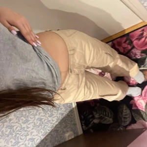 Beiga cargopants från Perfect Jeans/ Gina - Säljer ett par beiga cargopants från Perfect Jeans. Byxorna har flera fickor på sidorna och en rak, loose passform. Perfekta för en avslappnad och trendig stil.