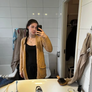 Beige stickad kofta från Gina Tricot - Mysig beige stickad kofta från Gina Tricot med öppen front och två fickor. Perfekt att slänga på sig över en topp. Långärmad och i mjukt material som känns skönt mot huden. 🌺
