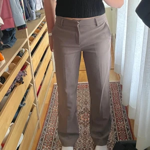 Mörk-beigea kostymbyxor med raka ben - Säljer ett par bruna kostymbyxor från gina som unte kommer till användning. Bra passform och långa i benen