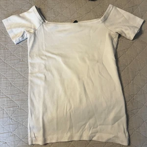 Vit  topp från Gina Tricot - Säljer en vit  topp från Gina Tricot i mjuk bomull. Toppen har korta ärmar och en figurnära passform, perfekt för en stilren och enkel look.