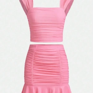 Rosa volangkjol med rynkade detaljer - Supersöt rosa kortkjol med volangkant och rynkade detaljer längs hela kjolen. Kjolen är figurnära och har en riktigt fräsch och ungdomlig vibe. Perfekt för dig som vill sticka ut med en färgglad och trendig look.