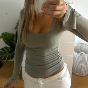 Långärmad topp - Supersnygg grön långärmad topp med tight passform och rundad urringning. Skulle säga att färgen är en liten grå-aktig ljusgrön, jättefin! Säljs inte i denna färgen på Gina längre