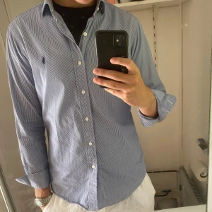 Randig blå skjorta från Polo Ralph Lauren - Snygg blå- och vitrandig skjorta från Polo Ralph Lauren, modell Regent Custom Fit. Nypris: 1600kr