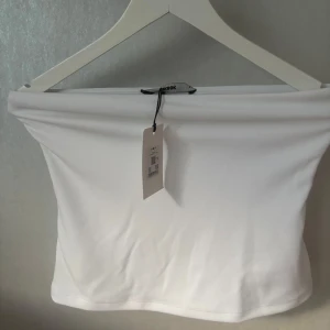 Vit tub topp - En vit tub topp som är helt oanvänd från bikbok. Råkade köpa i en storlek för stor och det krånglade med returen. Inte genomskinlig alls och perfekt till en lång fin kjol kanske🩷