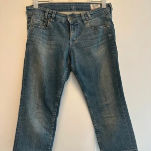 Blåa trekvartslånga jeansbyxor från  Mexx - Snygga blåa trekvartslånga jeansbyxor från Mexx med klassisk femficksdesign och låg midja. Jeansen har en smal passform och slutar strax under knät, perfekt för en avslappnad och trendig look. Jeansen är i storlek 27