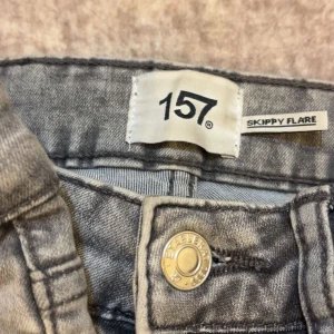 Gråa flare jeans från 157 - Ett par gråa jeans från 157 i modellen Skippy Flare. Jeansen har klassisk femficksdesign, utsvängda ben och normal midja. Snygg tvättad grå färg som passar till det mesta. Perfekta för dig som gillar retrovibbar och vill ha en cool siluett. 2 för 100 och 1 för 50  storlek 8-10år