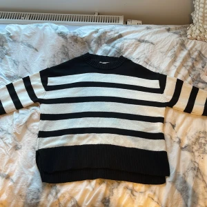Randig svartvit stickad tröja Gina Tricot - Snygg stickad tröja från Gina Tricot i svart och vitt med breda horisontella ränder. Tröjan har rund hals, långa ärmar och ribbade muddar vid ärmslut och nederkant. Tröjan har en del tecken på användning som t.ex lite nopprig och har en liten fläck som ni kan se på sista bilden men den syns knappt och går säkert att få bort. Tröjan är i storlek 134/140 men passar även mig som är ca 160 lång nästan perfekt. 