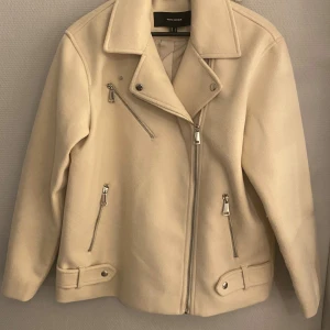 Jacka - Beige jacka från Vero Moda i ullmix med klassisk bikerstil. Jackan har silvriga dragkedjor.
