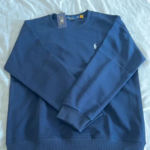 Ralph lauren sweatshirt - PRIS ÄR INTE HUGGET I STEN!👌🤩                 Färg: Mörkblå (navy) 	•	Storlek: M 	•	Skick: Helt ny, aldrig använd 	•	Detaljer: Rundhalsad sweatshirt med vit broderad Polo Ralph Lauren-logga på vänster bröst. 	•	Material: Klassisk, bekväm och stilren tröja i mjuk bomull.