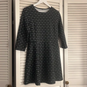 Svartvit mönstrad kortklänning - Snygg svartvit kortklänning med grafiskt rutigt mönster och trekvartsärm. Storlek L 