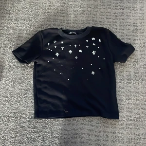 Jätte fin t-shirt från Zara🤍 - Svart t-shirt från Zara med korta ärmar och rund hals. Framsidan är dekorerad med vita pärlor och små blommor. Materialet känns mjukt och lite tjockare än vanlig bomull, den e ganska liten i storleken så passar personer med xs,xss också🤍