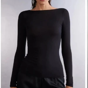 Svart intimissimi tröja - En stilren svart långärmad topp med båtringad hals. Sitter tight och har en minimalistisk look som passar till allt. Perfekt att styla med både jeans och kjol för en clean vibe. Skriv för bilder 💗