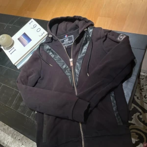 Svart kofta från Horspist  - Riktigt fin kofta med tryck av en orm och pärlor på och en badge på armen