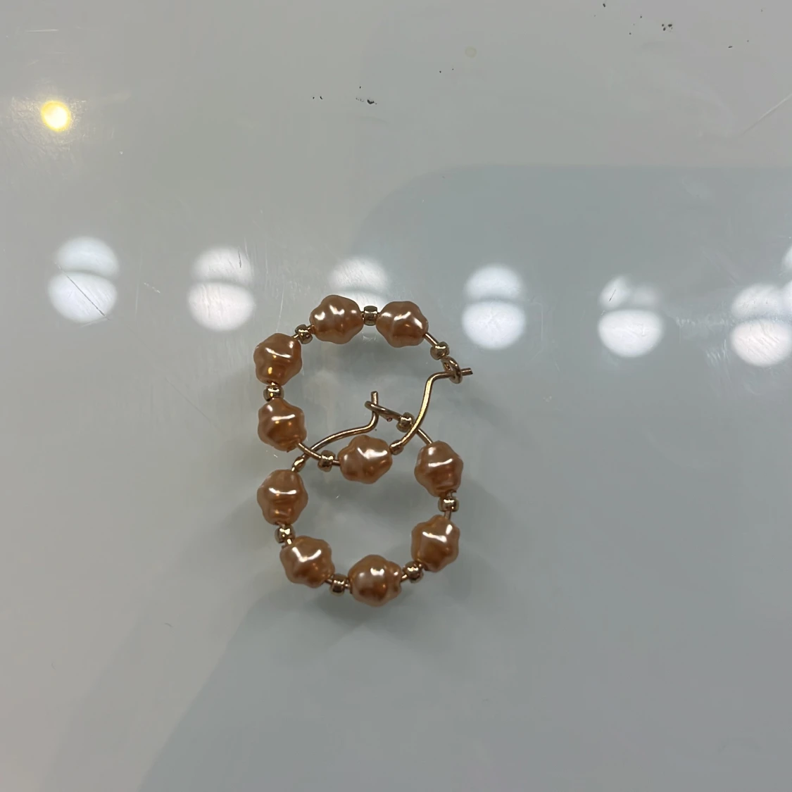 Guld örhängen med beiga pärlor