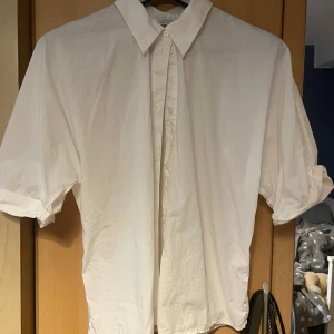 Vit kortärmad skjorta🤍 - Jättefin vit kortärmad skjorta som är upsydd vid armarna. Den är tidigare second hand men jag har endast använt den 1-2 gånger💕 skulle inte säga att den har något slitage.  Lappen med storlek är dock avklippt men passar mig ganska bra som oftast har S/36. Kan skicka mått annars om ni är intresserade 🤍