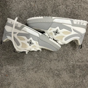 Louis Vuitton sneakers i vitt och grått - Säljer ett par Louis Vuitton Skate Sneakers i mycket fint skick. Köpta från ett seriöst resell-konto, men jag har redan samma modell i blått och därför säljer dessa vidare.  Storlek: 44 Skick: Nyskick Kvitto finns: Nej (kom inte med på köpet) Pris: 2790  Finns för avhämtning eller kan skickas. 