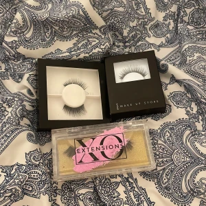 Lösögonfransar XO Extensions & Make Up Store - Tre par lösögonfransar: ett par dramatiska och fluffiga svarta från XO Extensions i genomskinlig ask med guldig bakgrund, samt två par mer naturliga svarta fransar från Make Up Store i svarta förpackningar. Perfekt för att lyfta din look med olika stilar.