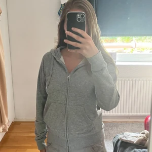 Grå hoodie - Mysig grå hoodie med dragkedja och huva från Cubus. Tillverkad i ekologisk bomull, har känguruficka framtill och ribbade muddar. Säljer då den inte kommer till användning längre 💗💗