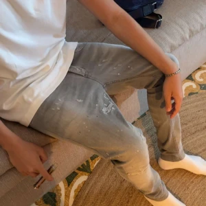 Dondup jeans  - Snygga grå skinny jeans från George med slitna detaljer och färgstänk för en cool, avslappnad vibe. Helt nya och köpa för cirka en månad sedan. 