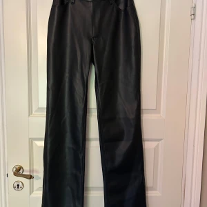 Svarta skinnbyxor från BikBok - Snygga svarta skinnbyxor från BikBok. Byxorna har raka ben, normal passform och klassisk midja med knapp och hällor för bälte. I princip aldrig använda 😍 Nypris 599:-, mitt pris: 170:- 