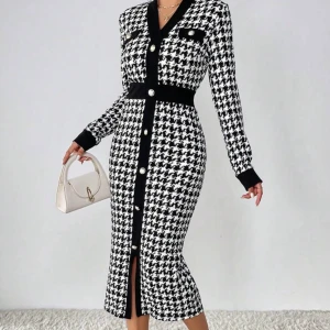 Svartvit rutig långklänning - Snygg långklänning i svartvitt rutigt mönster med markerad midja och långa ärmar. Klänningen har knappar framtill, v-ringning och dekorativa fickor vid bröstet. Perfekt för dig som gillar klassisk men trendig stil.