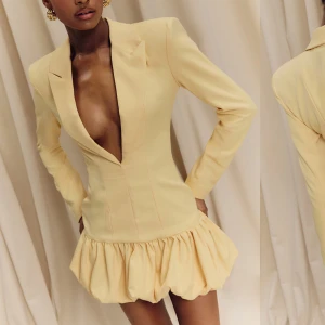 ljusgul kort blazerdress med volangkjol - Supersnygg ljusgul kort klänning med markerad midja, djup v-ringning och lång ärm. Kavajliknande överdel och voluminös volangkjol ger en unik och trendig look. Perfekt för dig som vill sticka ut med stilren elegans och cool siluett. Använd en gång så precis som ny 