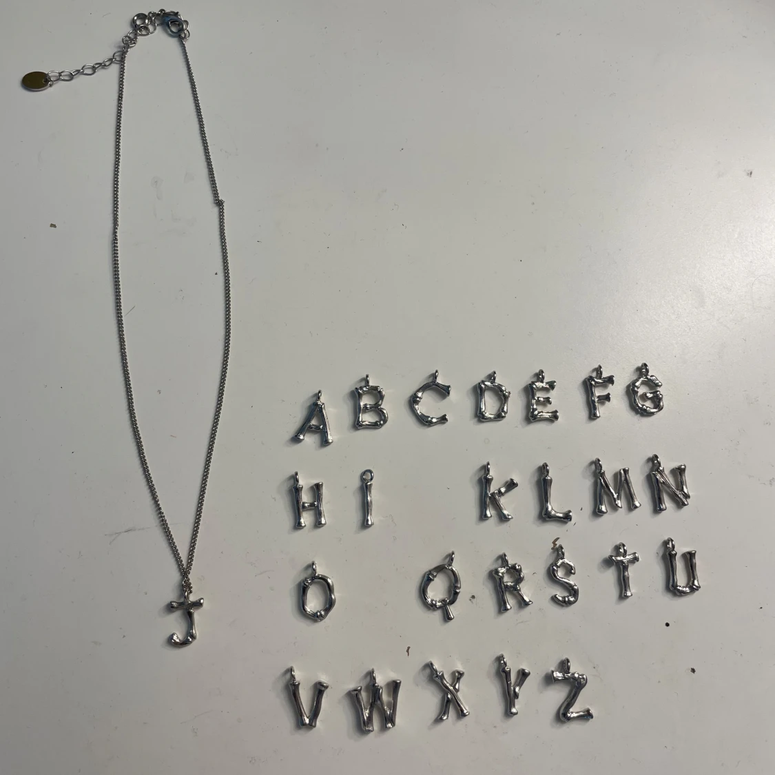 Bokstavshalsband i silver 