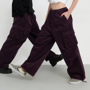 Mörklila cargobyxor i manchester - Säljer ett par mörklila cargobyxor från YOURTURN i mjuk manchester. Byxorna har bred passform, elastisk midja och stora fickor på sidorna. Perfekta för dig som gillar loose fit och streetstyle. Grymma att styla med sneakers eller boots. ORD pris: 699kr