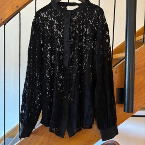 Svart spetsblus från Neo Noir - Supersnygg svart spetsblus från Neo Noir med långa ärmar och knappar framtill. Blusen har transparent spetsmaterial och klassisk💕 helt oanvänd!! Den är i storlek 40 men är liten i storleken kan skicka bild på lappen där storlek står 💕ny pris 549kr!!