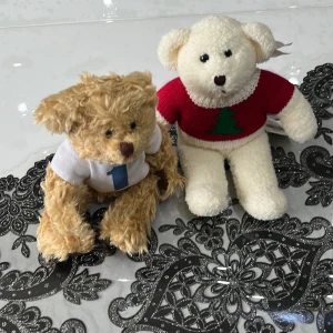Röd jultröja med gran från Teddy House - Supersöt stickad röd tröja med grön julgran på bröstet från Teddy House. Tröjan har vita detaljer vid halsen och är perfekt för att ge nallebjörnen en extra julig look. Passar dig som vill ha något gulligt och festligt till vinterns mys.