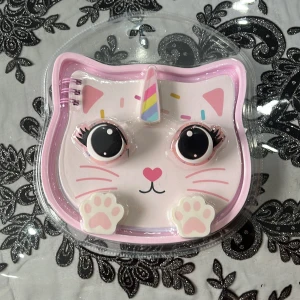 Stationery Set Cute Cat - Supersött anteckningsset i form av en katt med enhörningshorn! Perfekt för dig som vill göra skolarbetet roligare eller skriva ner dina tankar. Innehåller anteckningsbok, suddgummin och clips – allt i en unik och lekfull design som sticker ut.