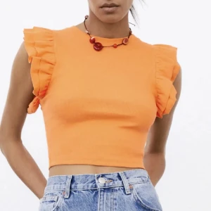 Volangtopp - Superfin orange croppad topp med volangdetaljer på axlarna. Toppen är sparsamt använd och är från Zara💓