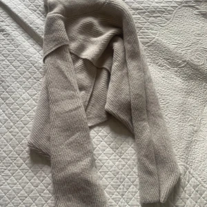 Beige ribbstickad tröja från Cider - Snygg och bred beige tröja från Cider i ribbstickat material. Tröjan har en mjuk känsla och en stilren look. Perfekt för extra värme under kyliga dagar.