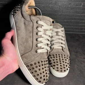 Christian Louboutin sneakers  - Hej säljer dessa ÄKTA Louboutin skor i beige färg nitar fram och bak. Storlek 45, skick 10/10 helt nya enbart testade inomhus. OG/tillbehör inget därför det lägre priset. Nypris 10’000kr