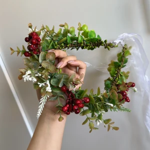 Blommig midsommarkrans med röd bär - Superfin blommig krans med gröna blad, röda bär och små vita blommor. Kransen har en transparent vit rosett baktill som ger en extra söt touch. Perfekt för midsommar eller studentfirande. Sitter bekvämt på huvudet och är lätt att justera med bandet.