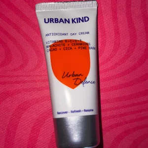 Urban Kind Antioxidant Day Cream - Urban Kind Antioxidant Day Cream med vitaminer B+C+D+E, malakit, ceramider, kakao, cica och tallbark. Kommer i en vit tub med orange detalj och silverfärgat lock. Perfekt för dig som vill boosta huden med näring och skydd.
