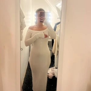 Vit lång offshoulder klänning - Supersnygg långklänning i vitt med offshoulder och långa ärmar. Tight passform som framhäver figuren och ger en clean, elegant look.